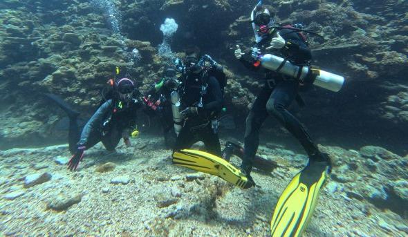 Dan Barshis poses for photo under water wearing scuba gear