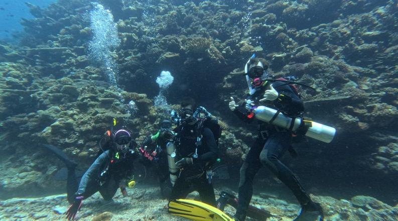 Dan Barshis poses for photo under water wearing scuba gear